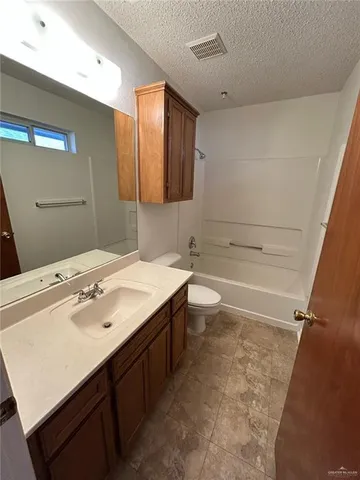 a spacious bathroom with a sink a toilet a mirror and bathtub
