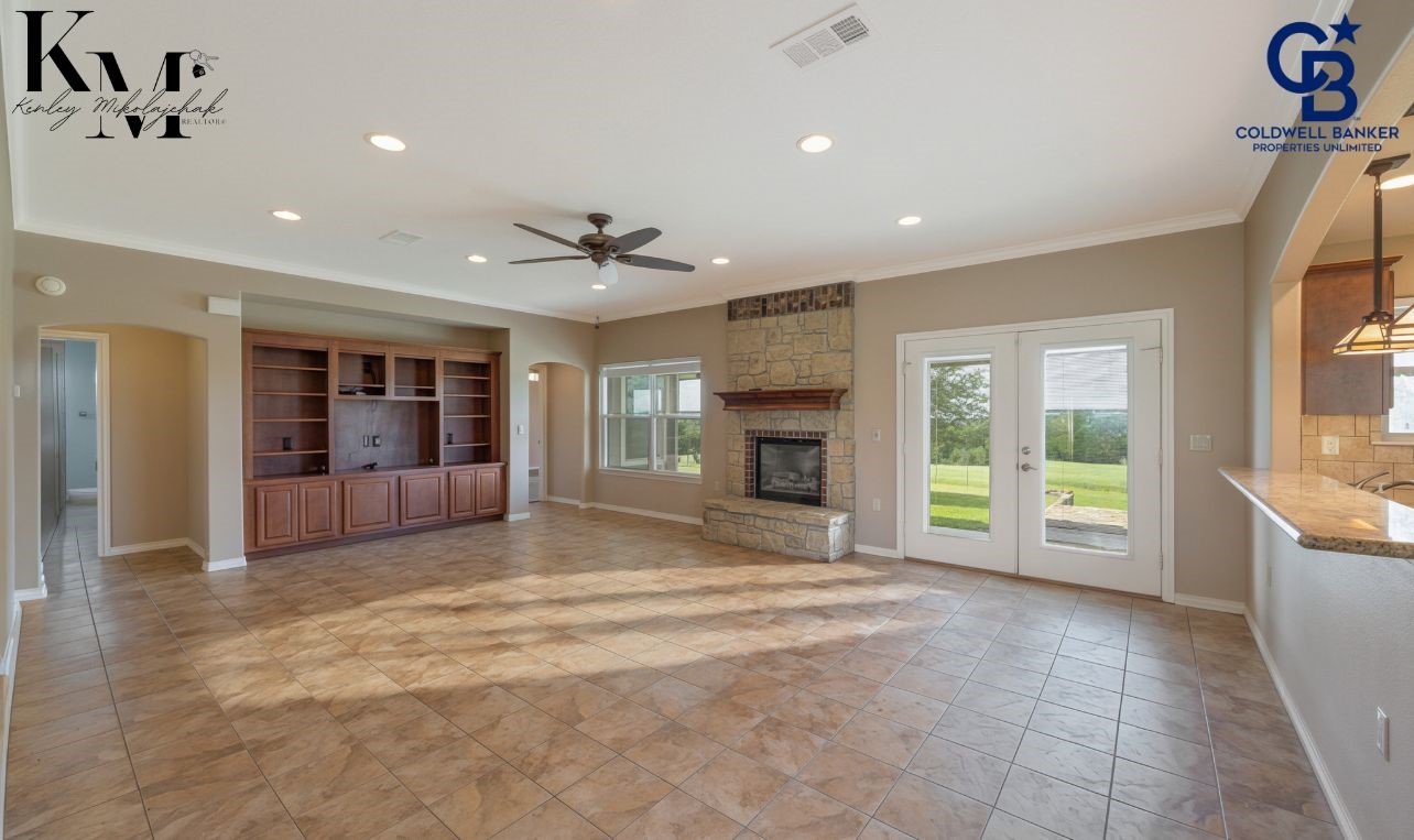 1980 Chappell Ridge Lane Brenham, TX 77833 - Photo 2 of 13 Spacious open-concept living area anchored by a cozy fireplace, perfect for gathering and everyday comfort.