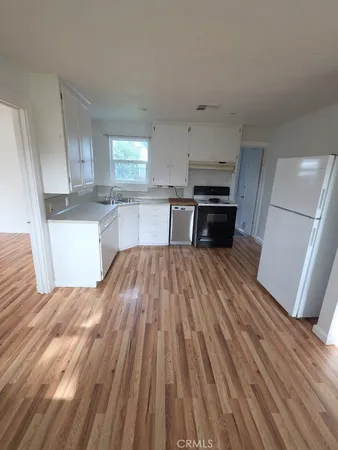 a kitchen with wooden floors and a white counter top