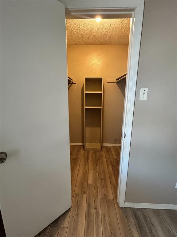 2818 South Fielder Road Arlington, TX 76015 - Photo 23 of 31 a view of walk in closet with wooden floor