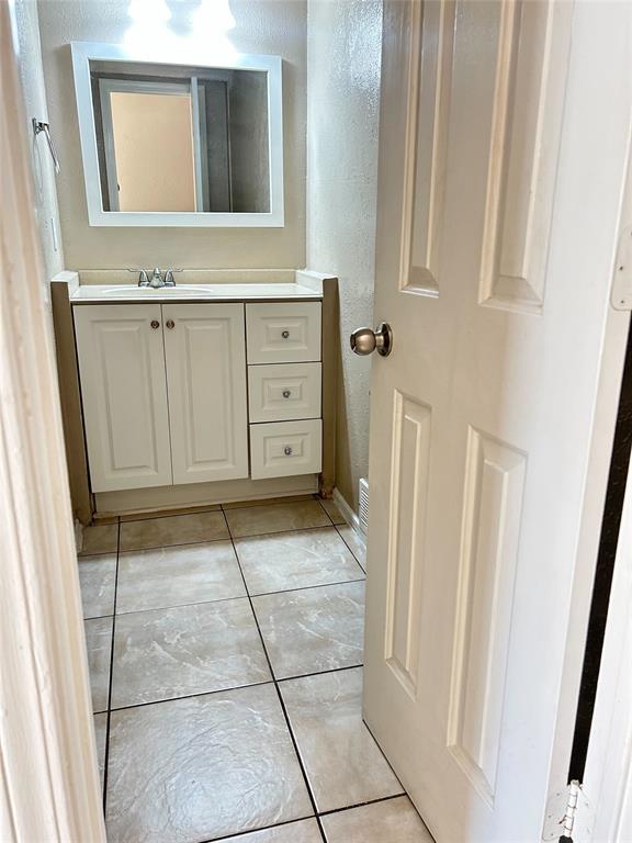 2818 South Fielder Road Arlington, TX 76015 - Photo 10 of 31 a bathroom with a sink a mirror and cabinets