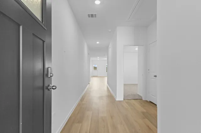 a view of a hallway with wooden floor