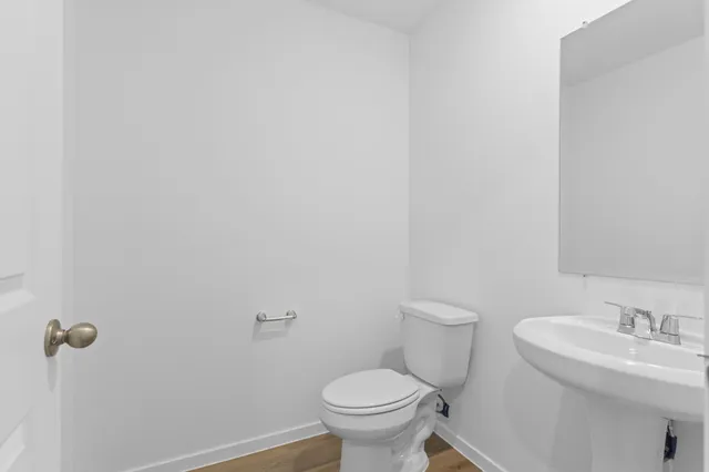 a bathroom with a toilet a sink and mirror