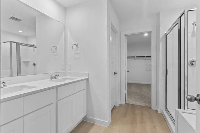a spacious bathroom with a shower sink and mirror