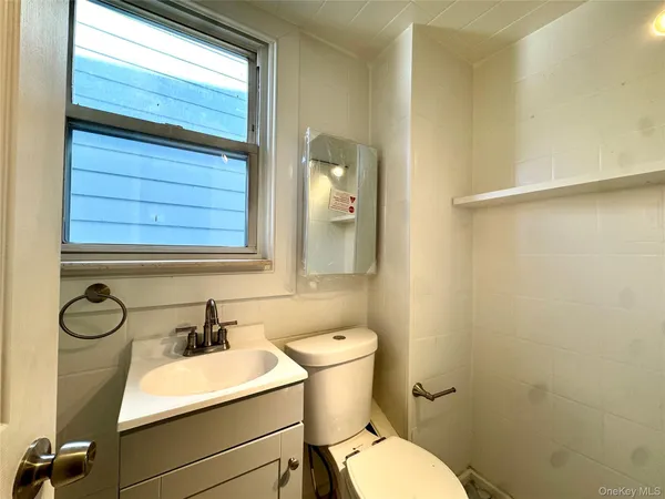 a bathroom with a sink mirror vanity and toilet