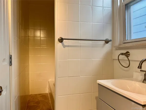 a bathroom with a sink shower and a mirror