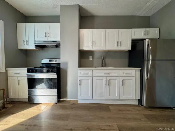 a kitchen with white cabinets and stainless steel appliances