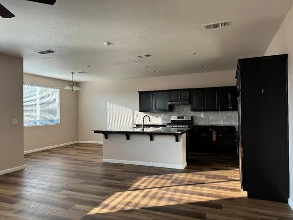 a kitchen with stainless steel appliances kitchen island granite countertop a stove a sink and a refrigerator