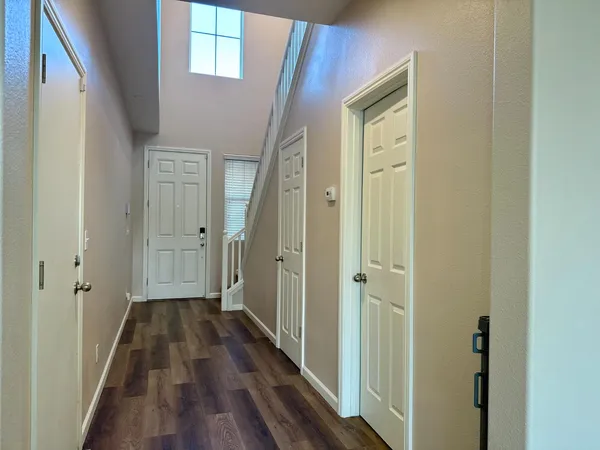 a view of a hallway with wooden floor and closet area