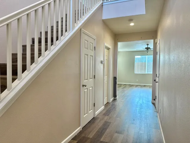a view of a hallway with wooden floor and staircase