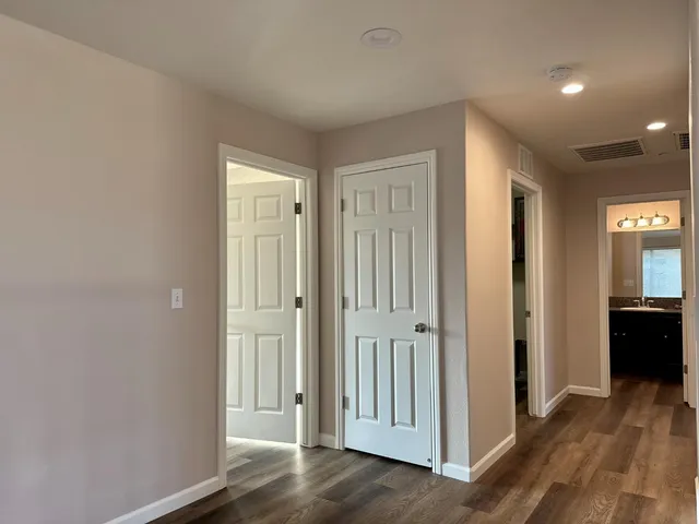a view of a hallway with wooden floor