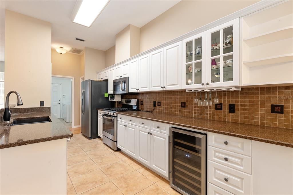 10160 Southwest 48th Place Gainesville, FL 32608 - Photo 16 of 68 a kitchen with stainless steel appliances granite countertop a stove a sink and a refrigerator