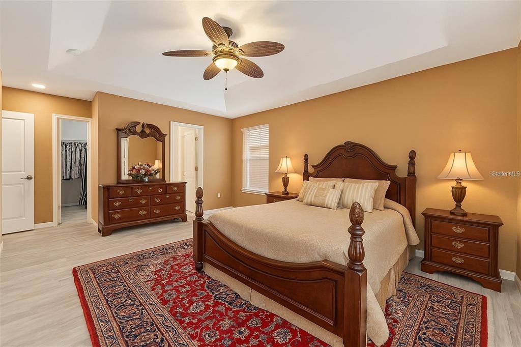 10160 Southwest 48th Place Gainesville, FL 32608 - Photo 20 of 68 a bedroom with a bed a lamp and a dresser