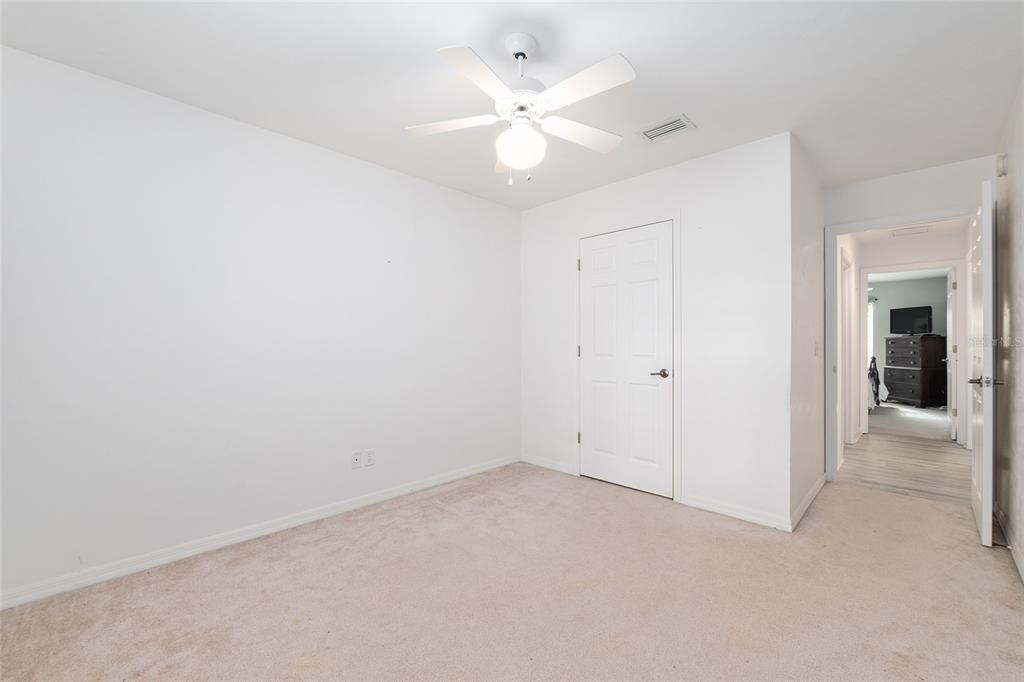 10160 Southwest 48th Place Gainesville, FL 32608 - Photo 37 of 68 an empty room with a chandelier fan and windows
