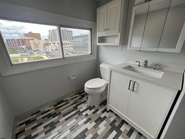 a bathroom with a sink a toilet and a window