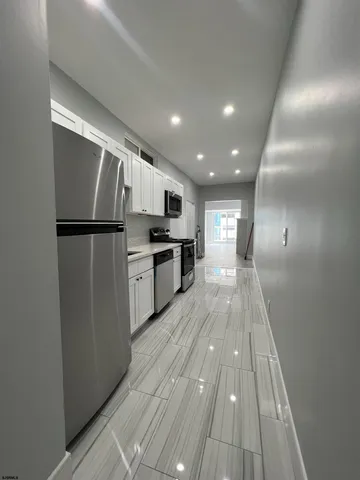 a kitchen with wooden floor and electronic appliances