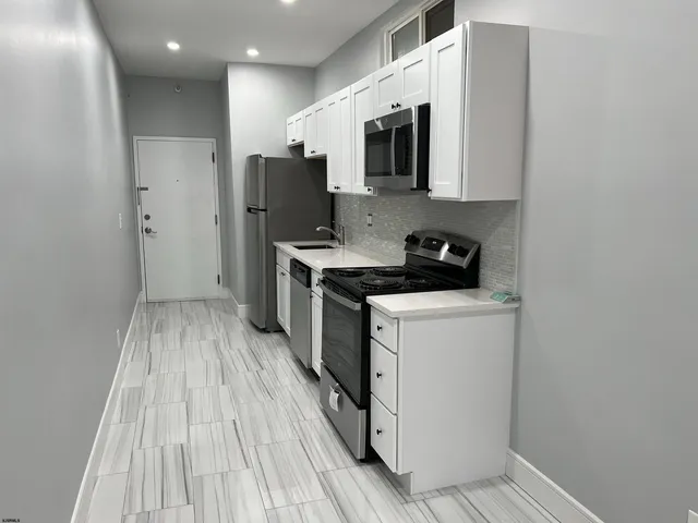 a kitchen with stainless steel appliances a refrigerator a stove a microwave and cabinets