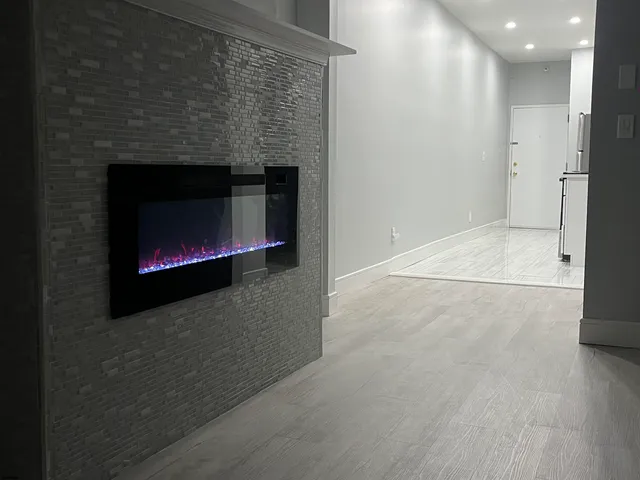 an empty room with wooden floor and a fireplace