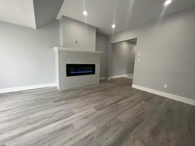 an empty room with wooden floor and fireplace