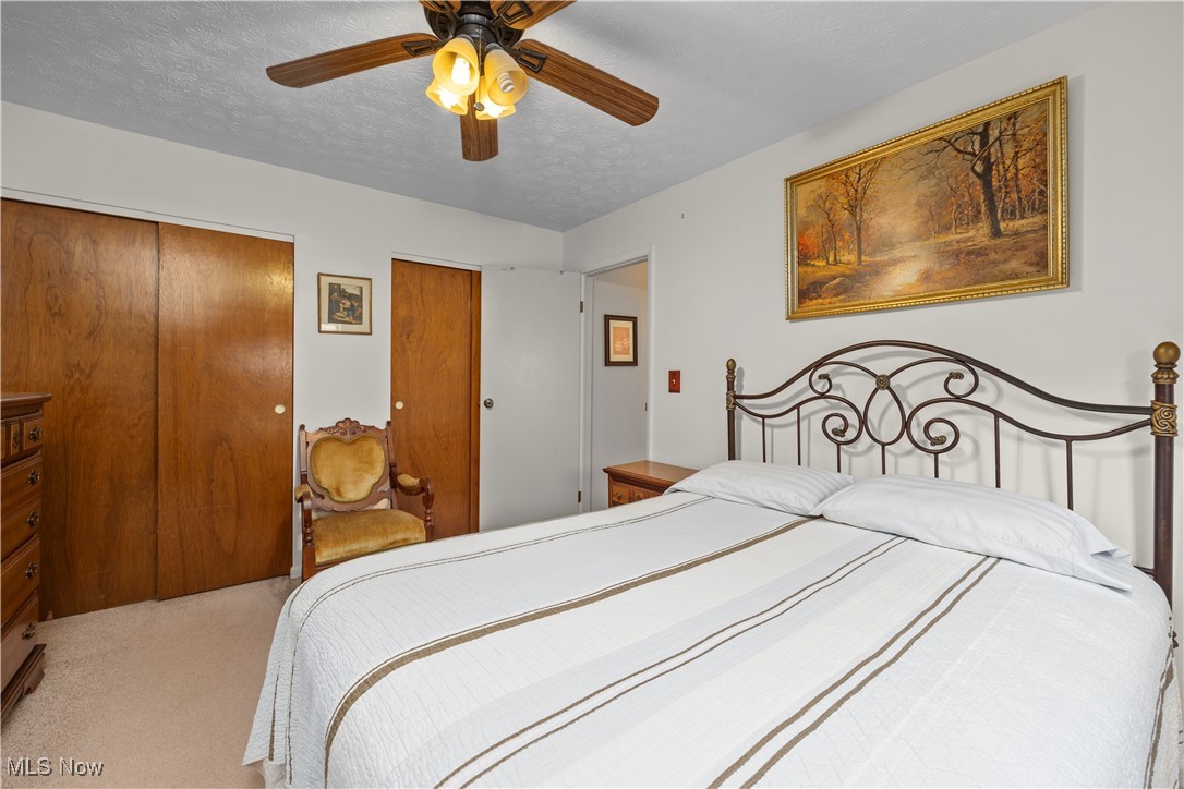 215 Sunset Road Avon Lake, OH 44012 - Photo 24 of 32 Carpeted bedroom featuring a ceiling fan, multiple closets, and a textured ceiling