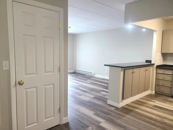 a view of a hallway with closet and wooden floor