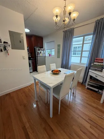 a view of a dining room with furniture a chandelier and wooden floor