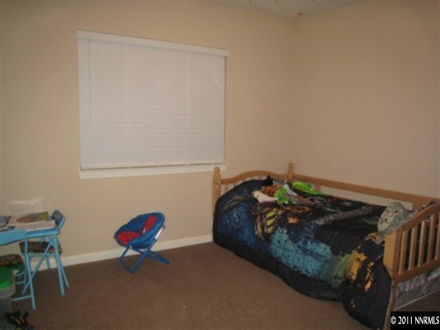 8960 Yeager Street Reno, NV 89506 - Photo 7 of 10 a bed sitting in a bedroom next to a window