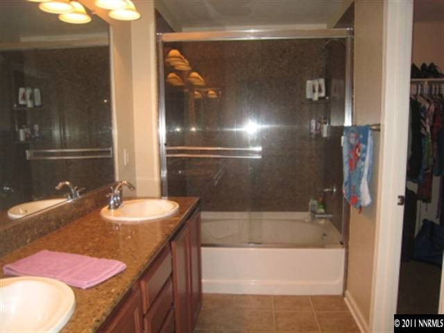 8960 Yeager Street Reno, NV 89506 - Photo 8 of 10 a bathroom with a granite countertop sink and a mirror
