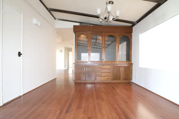a room with wooden floors and windows