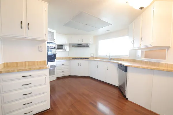 a kitchen with granite countertop white cabinets and white appliances