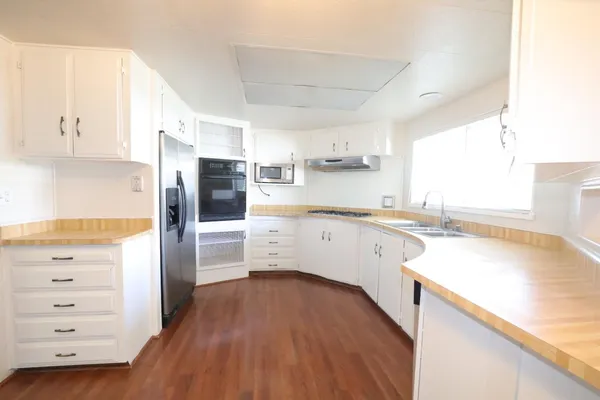 a kitchen with a refrigerator a sink and wooden cabinets