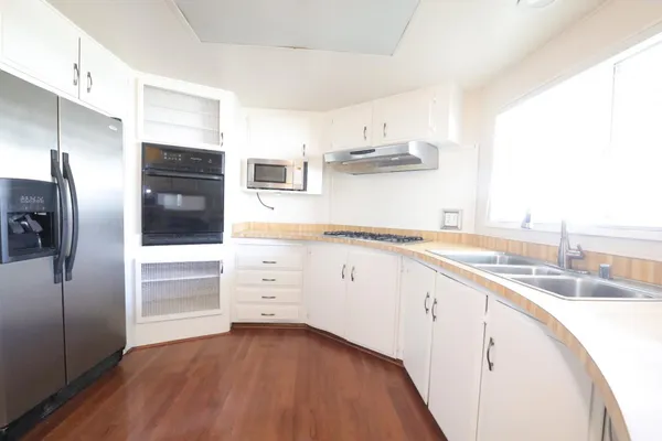 a kitchen with stainless steel appliances granite countertop a refrigerator and a sink