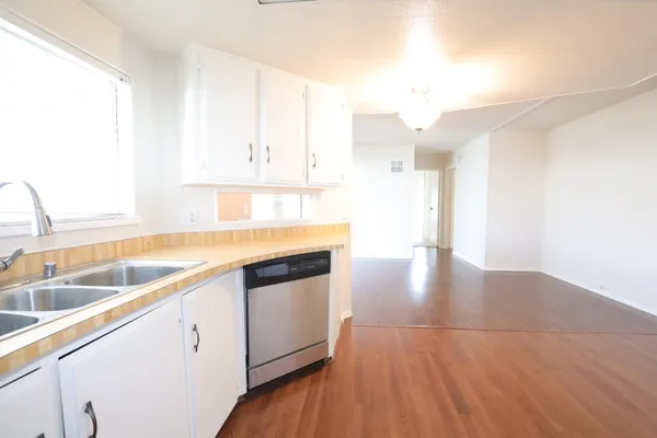 a kitchen with granite countertop a sink a counter space and cabinets