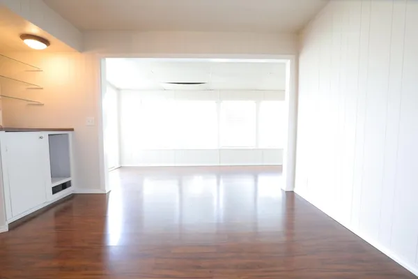 a view of empty room with wooden floor