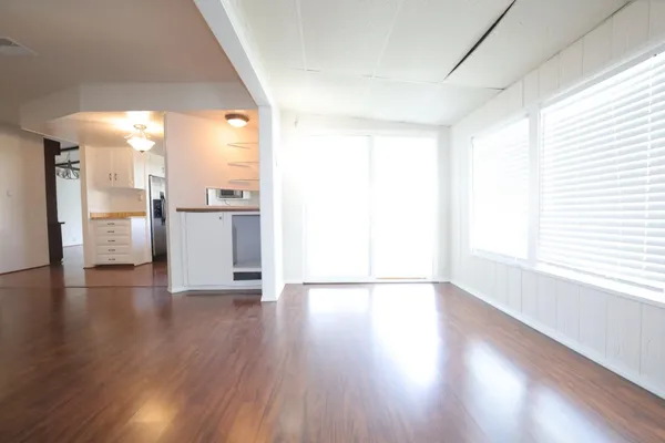 a view of a kitchen with a fridge and wooden floor