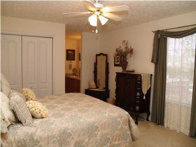 203 Bay Grove Road Freeport, FL 32439 - Photo 5 of 12 a bedroom with a bed and a chandelier