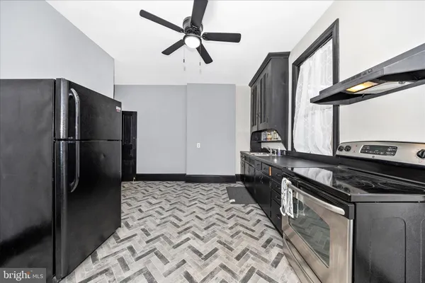 a kitchen with stainless steel appliances granite countertop a refrigerator a stove and a sink