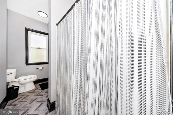 a bathroom with a toilet a sink and a window