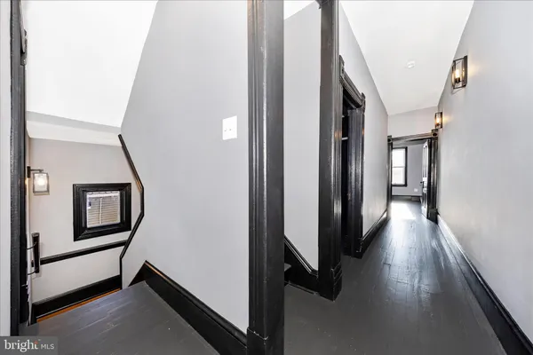 a view of a hallway with wooden floor and stairs