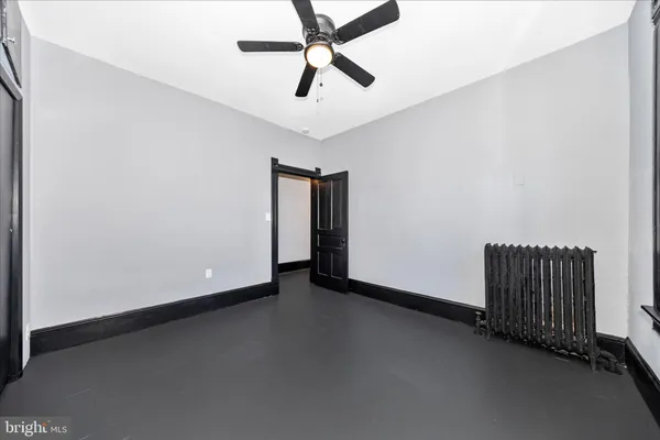 an empty room with a ceiling fan and carpet