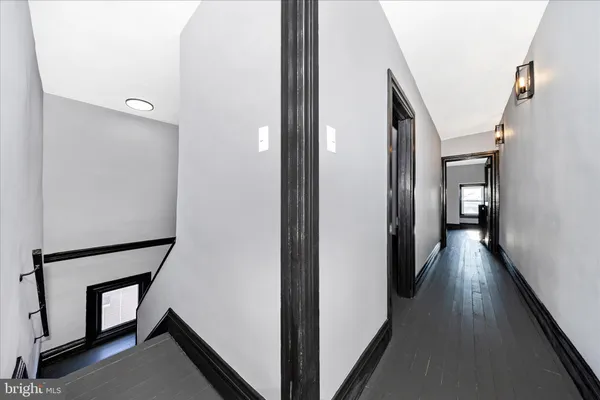 a view of a hallway with wooden floor and staircase