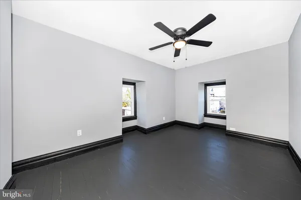 a view of a livingroom with a ceiling fan and wooden floor