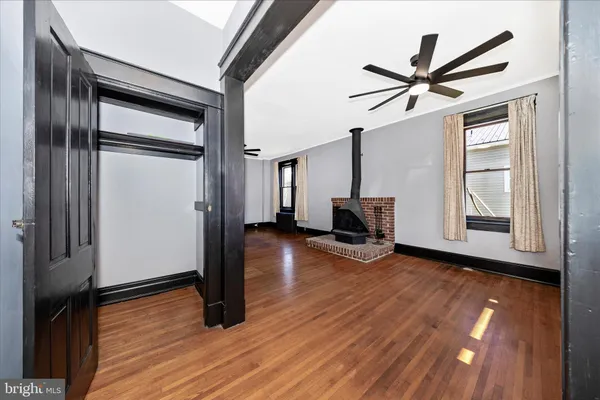 a view of a livingroom with wooden floor and a ceiling fan