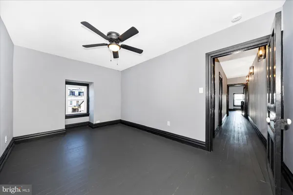 a view of a livingroom with a ceiling fan and wooden floor
