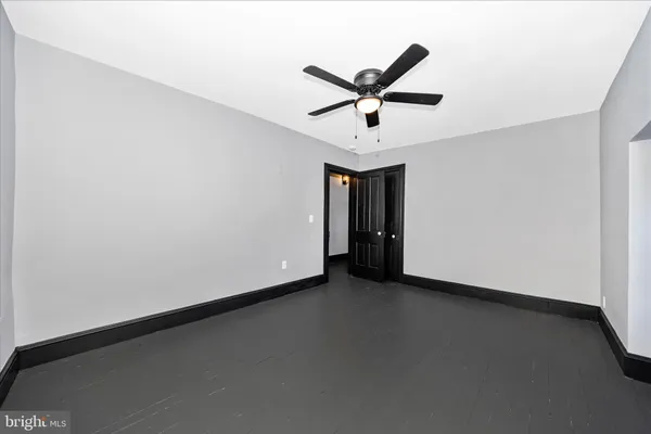 an empty room with a ceiling fan and window