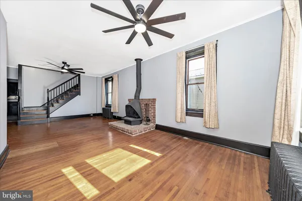 a view of a livingroom with wooden floor and a ceiling fan