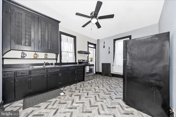 a kitchen with a sink a refrigerator and cabinets