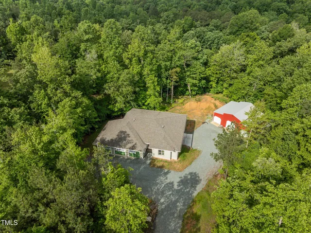 an aerial view of a house with yard and swimming pool