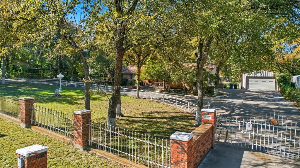Showcasing a beautiful curb appeal with a circular driveway and electric gate.
