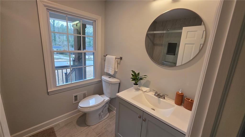 610 Glenforest Road Atlanta, GA 30328 - Photo 23 of 44 a bathroom with a toilet a sink and a mirror